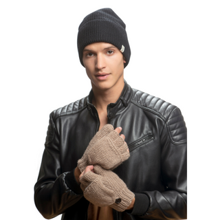A person wearing a black beanie, black leather jacket, and beige Fingerless Gloves With Button Flap and Fleece Lining holds the zipper of their jacket with one hand while the other hand is clenched. The background is plain white.