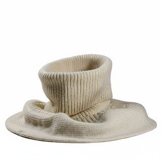 The Hank Neckwarmer, a beige knitted accessory combining features of a turtleneck collar and a wide-brimmed hat, is displayed against a plain white background.