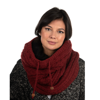 A woman wearing a burgundy merino wool Lou Neckwarmer.