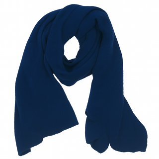 The Air Wrap Scarf, a long, textured dark blue merino wool accessory handmade in Nepal, is displayed in a loose, curved shape on a white background.