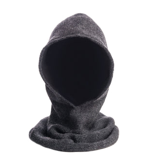 The Roll Hood, a handmade gray wool hooded scarf from Nepal with a textured design, is shown upright on a white background. The open hood drapes in folds around the base, and no mannequin or face is visible inside.