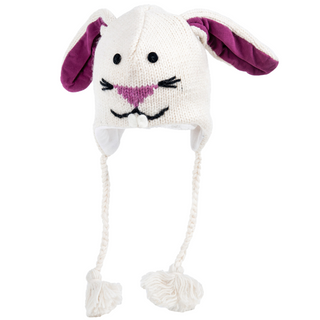 The Bunny Hat is made from soft merino wool and features a bunny face with black eyes, a pink nose, an embroidered mouth, long ears lined in purple fabric, and braided tassels on each side.