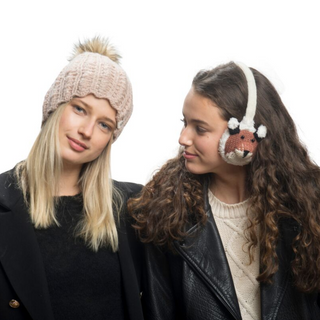 Two girls, one wearing Fox Earmuffs and a black coat, the other with curly hair and a leather jacket, are standing side by side against a white background. The girl on the right